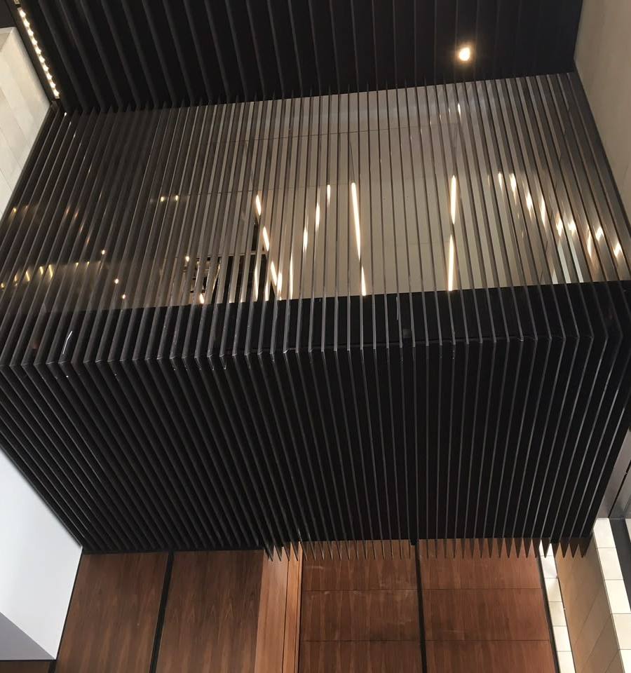 Slatted timber and black ceiling feature above a double-height void