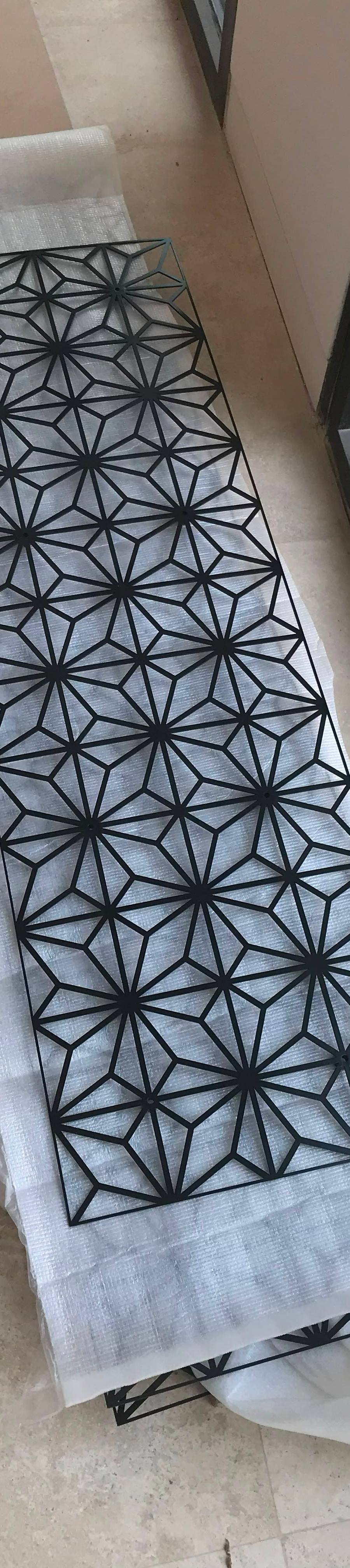 Laser-cut metal screen with a starburst pattern before installation