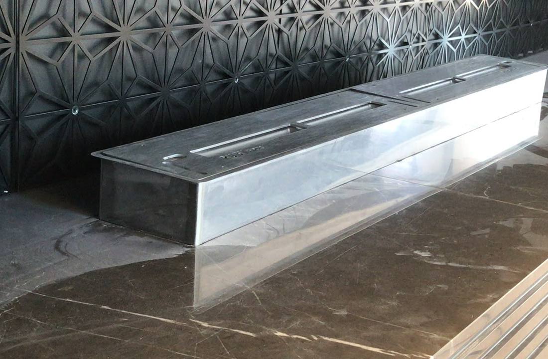 Linear fireplace burner set into polished dark marble