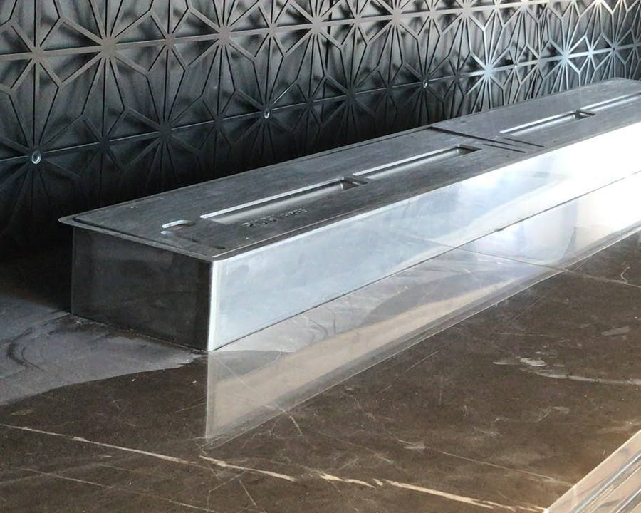 Linear fireplace burner set into polished dark marble
