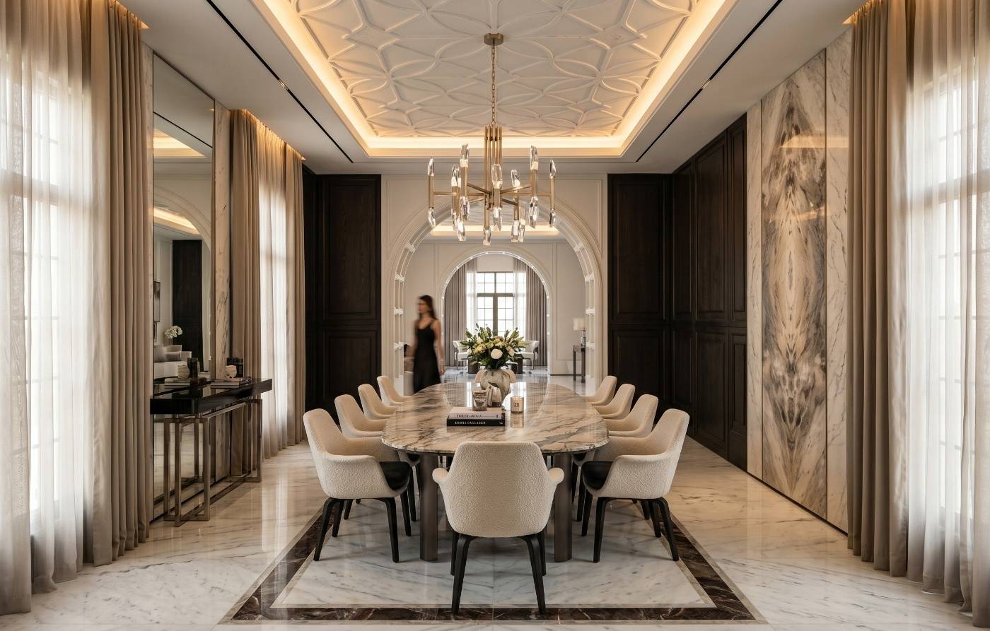 Luxury dining room in a Dubai villa renovation with white marble table, dark wood paneling, brass chandelier and mirrored walls