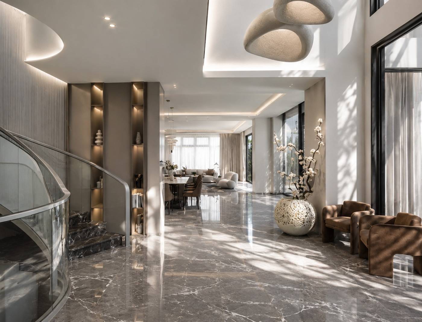 Curved marble staircase with glass railing leading into an open plan living and dining area in a refurbished Dubai villa