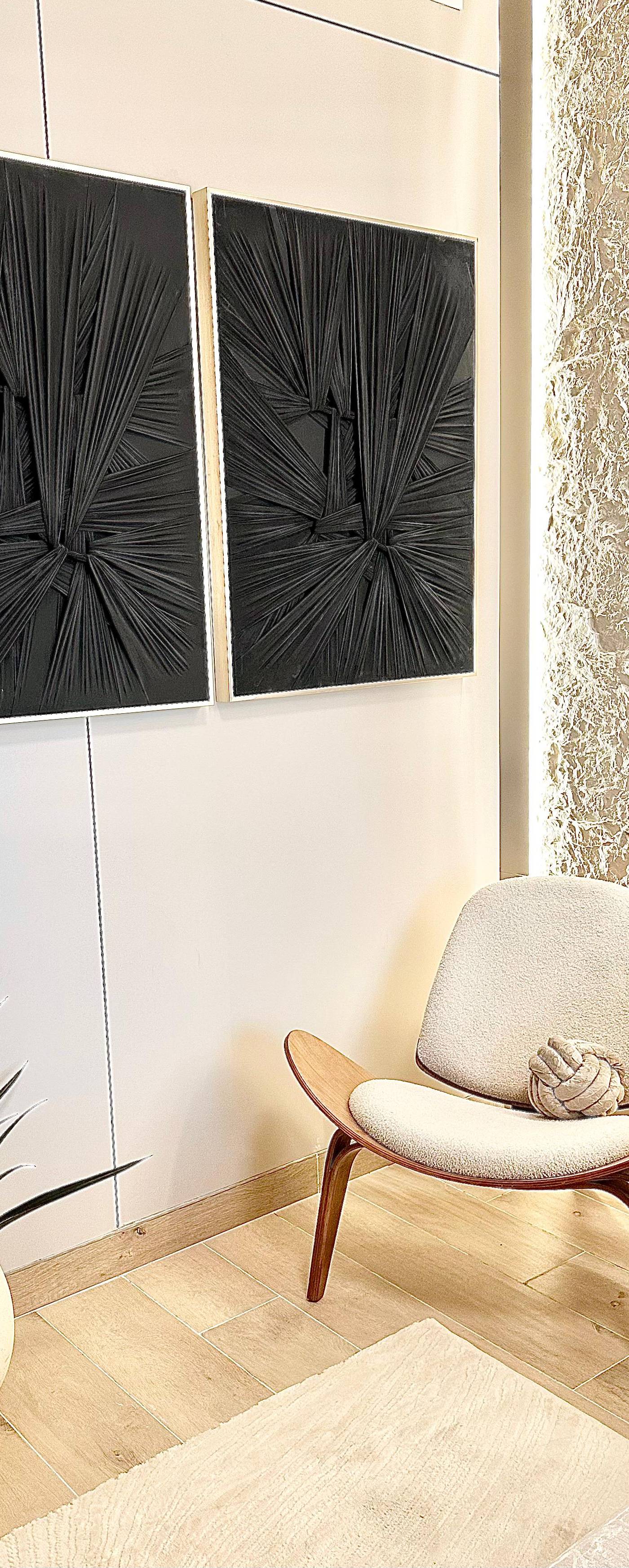 Cozy interior corner with black artworks and cream lounge chair in a <a href=