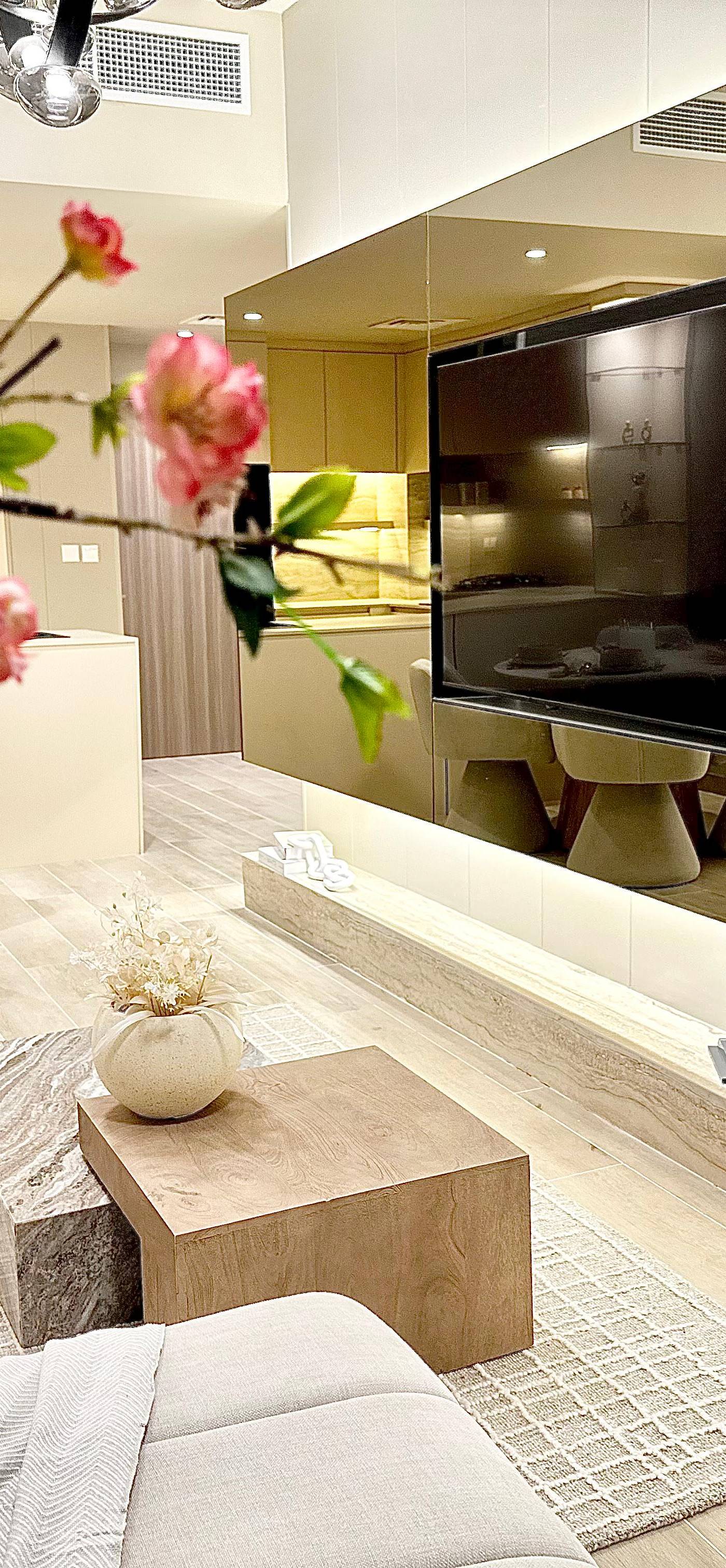 Open-concept living and dining area in a luxury villa fit-out Dubai with marble and wood coffee table, sectional sofa and integrated television