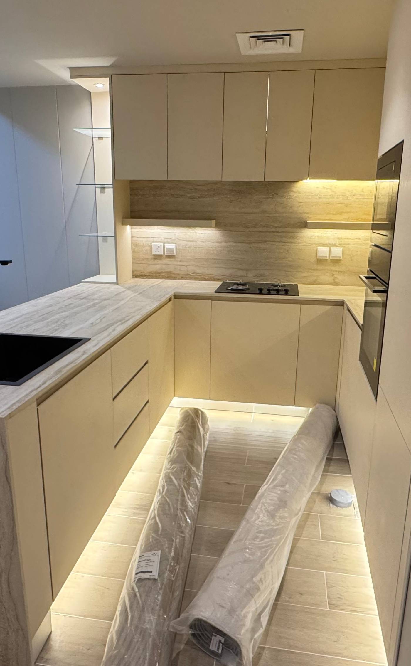 Modern luxury kitchen in a Dubai villa renovation featuring beige matte cabinets and travertine-look countertop