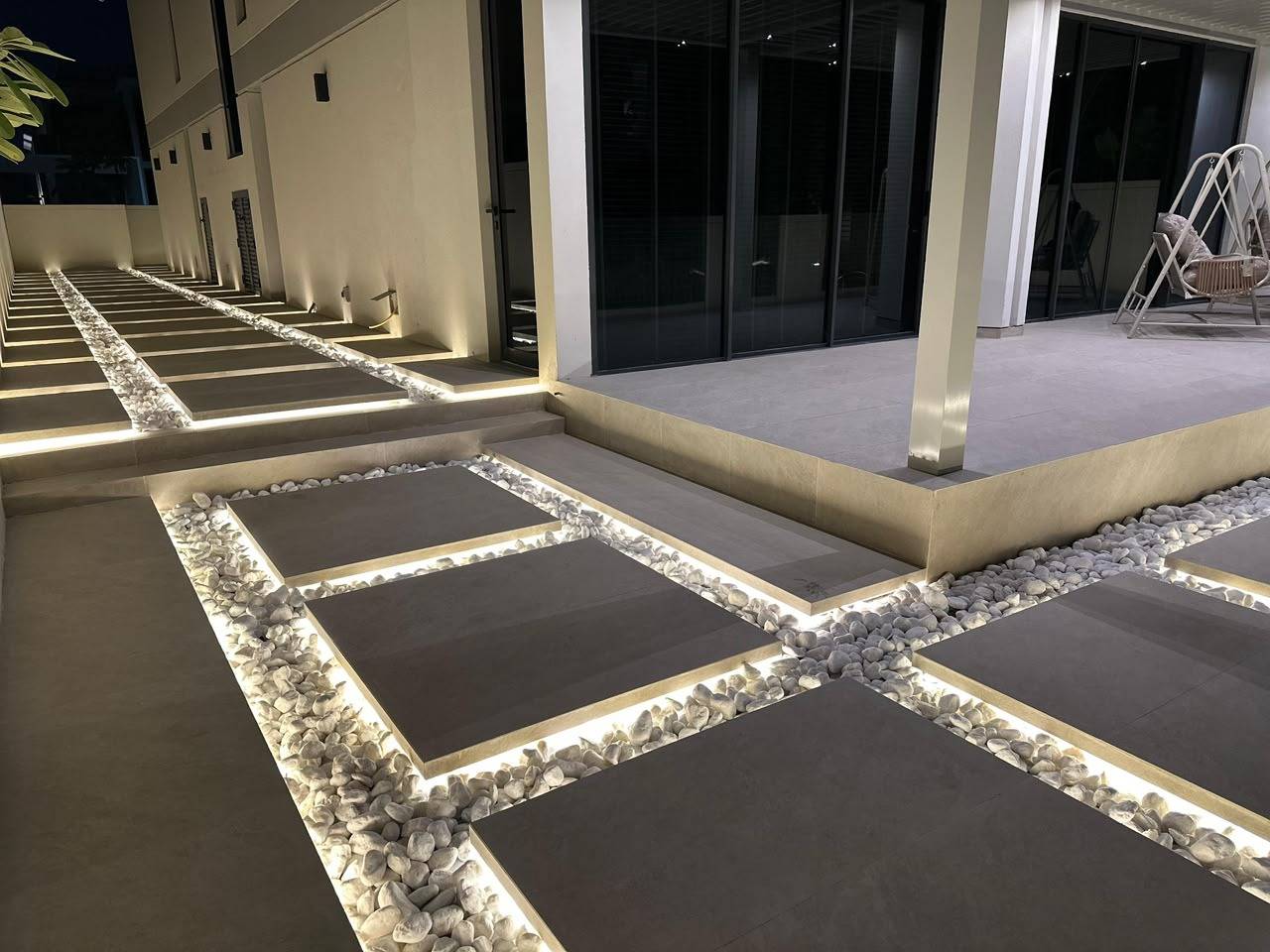 Turnkey villa fit-out Dubai exterior pathway with grey tiles LED strips and pebbles at night