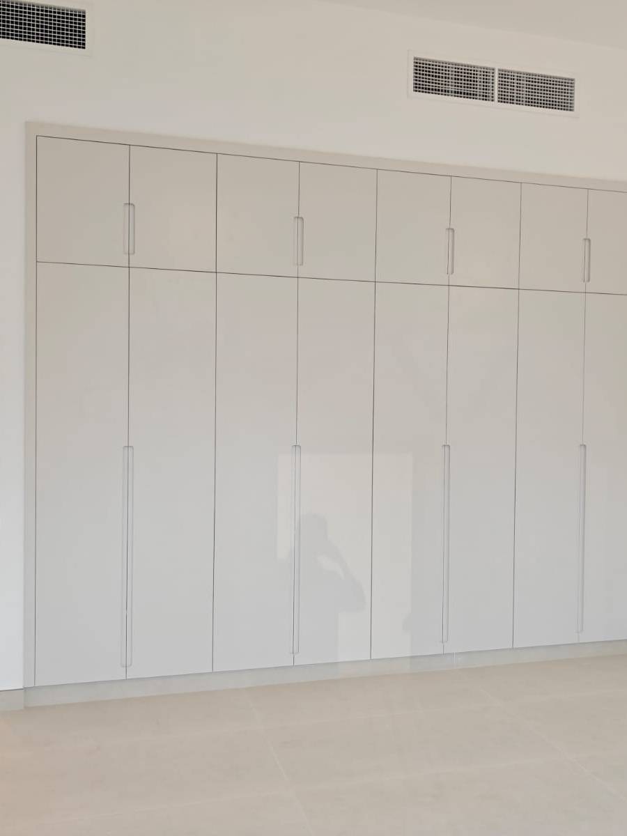Fitted bedroom wardrobes by Lacasa Line — high-gloss white fronts with recessed handles
