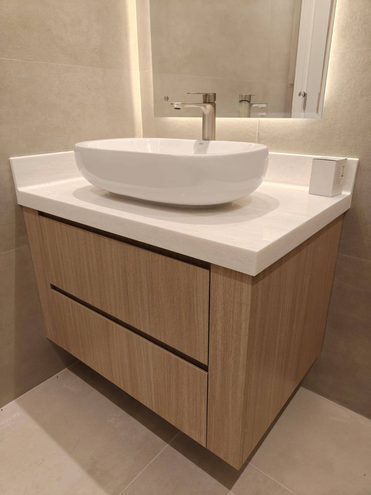 Freshly renovated modern bathroom with floating light wood vanity, white quartz countertop and vessel sink in a Dubai villa renovation