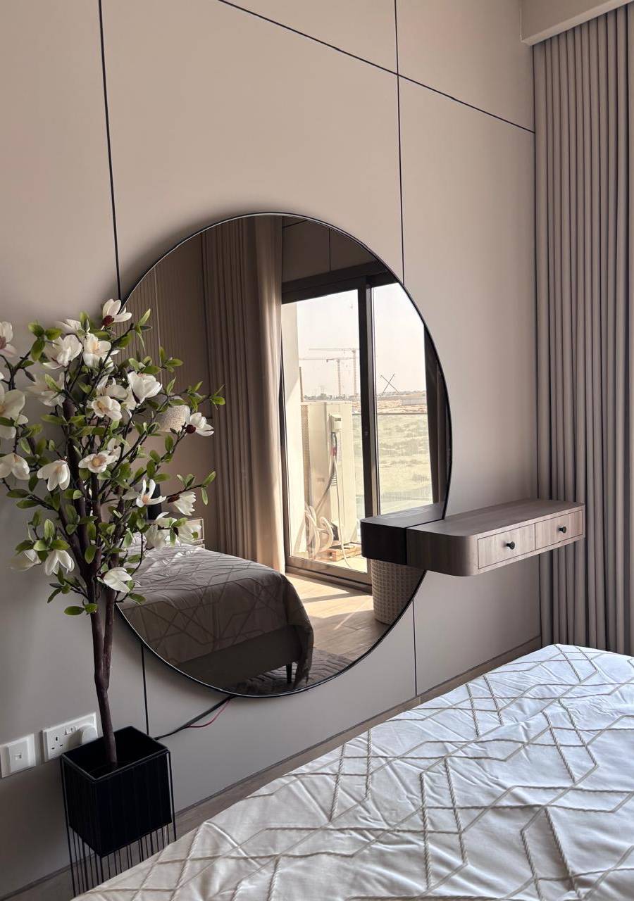 Bedroom wall panelling by Lacasa Line with a round mirror and floating shelf