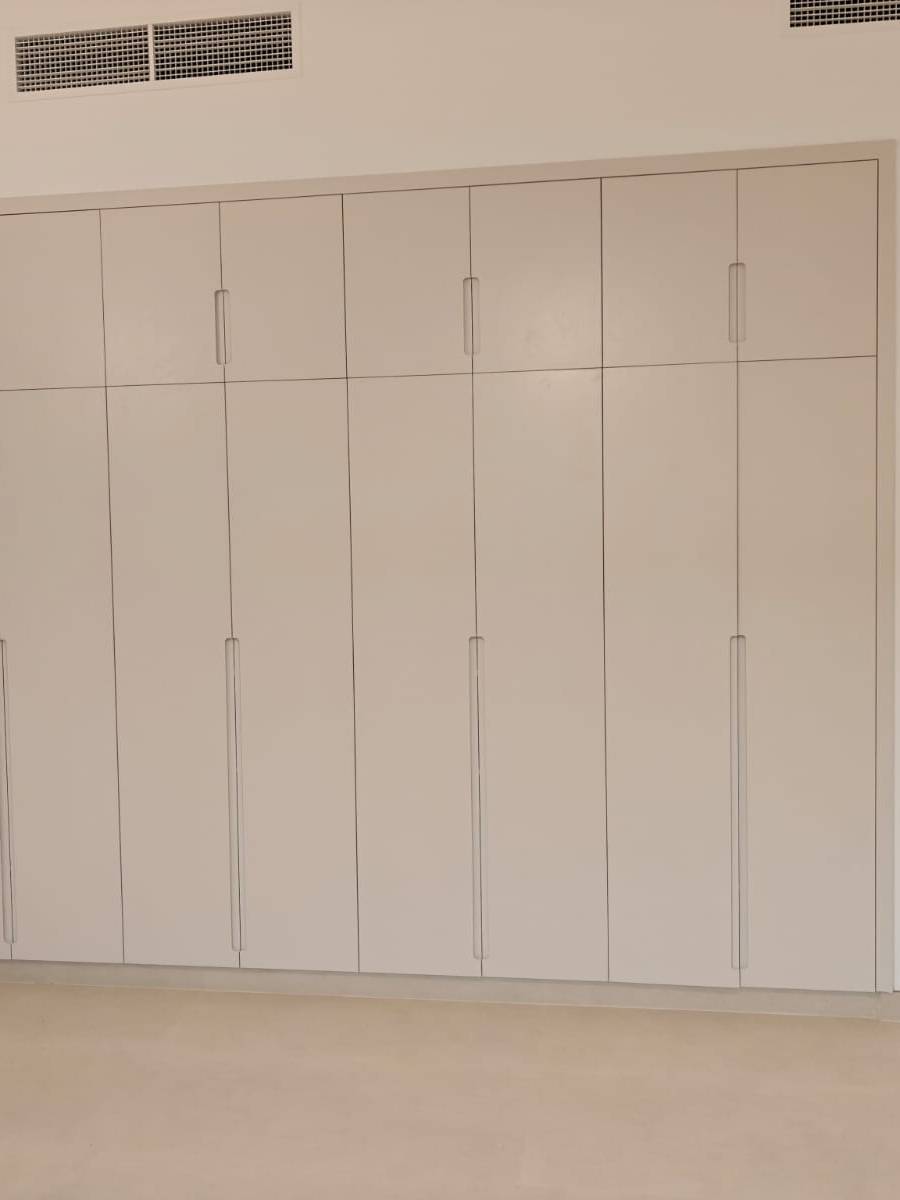 Full-height beige fitted wardrobes by Lacasa Line, handleless fronts
