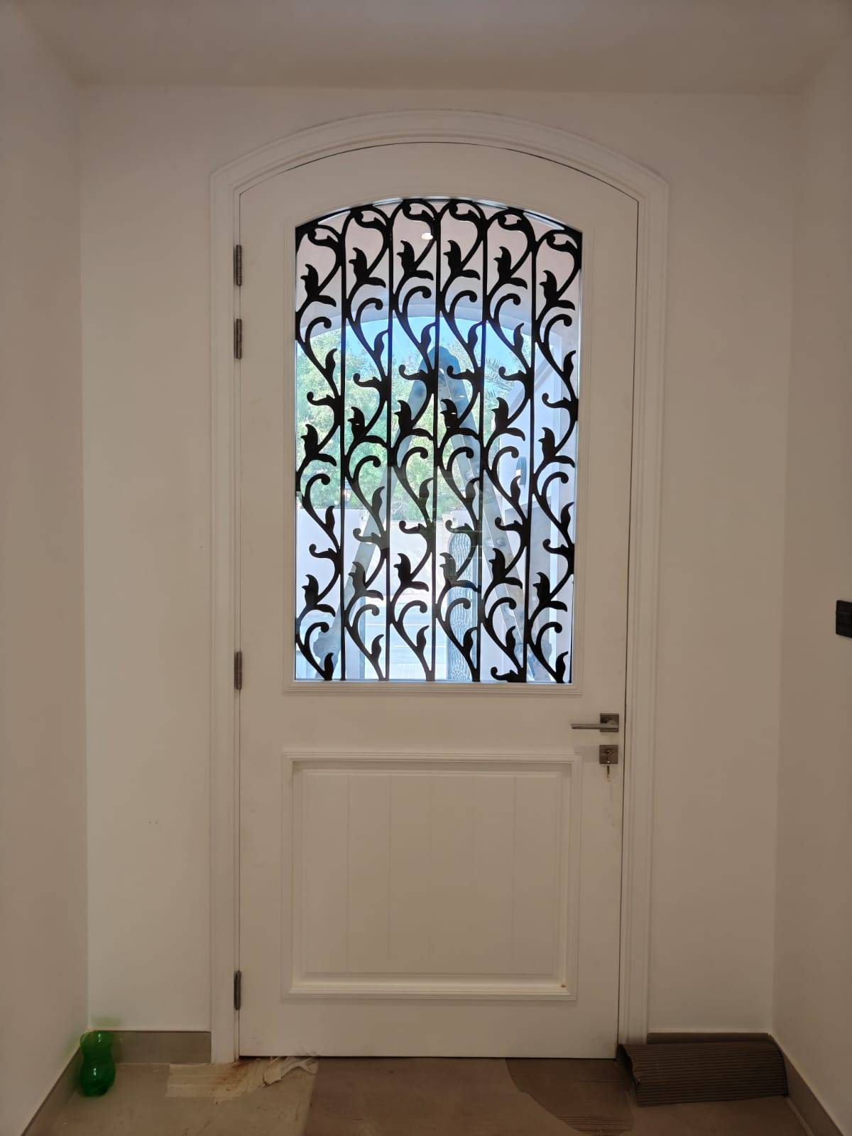 Recently completed turnkey villa renovation Dubai hallway with white arched door and black iron grill