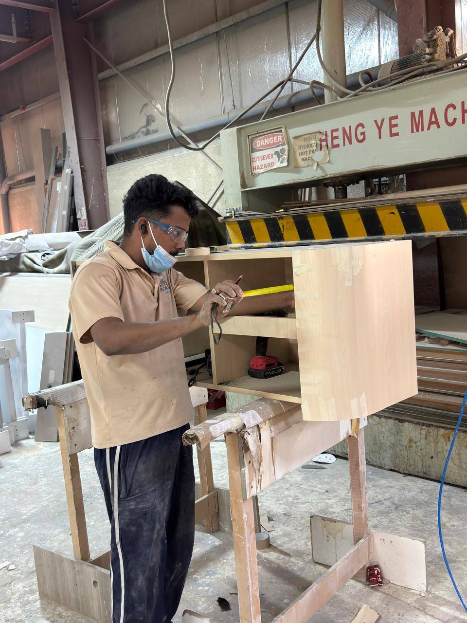 Skilled worker precisely measures a custom cabinet during <a href=