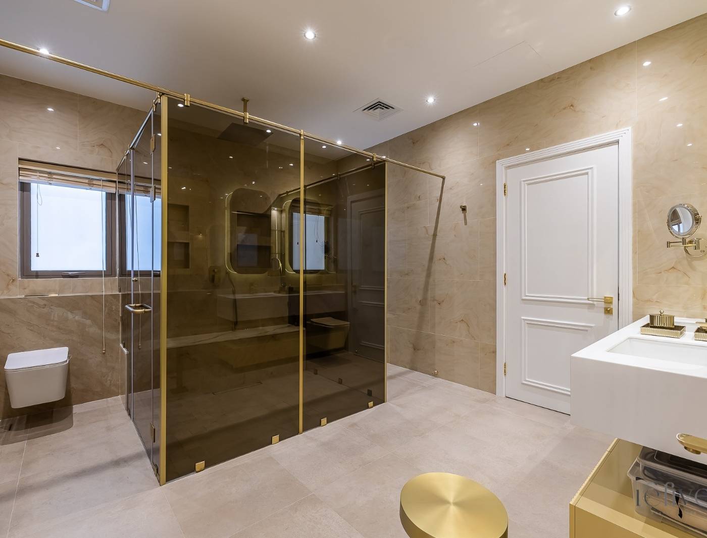 Bathroom upgrade with a dark frameless glass shower enclosure, gold hardware, floating white vanity and marble look wall tiles