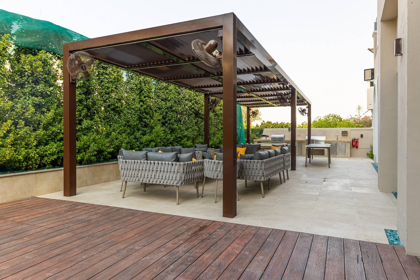 Finished outdoor living space with modern pergola and woven sofas