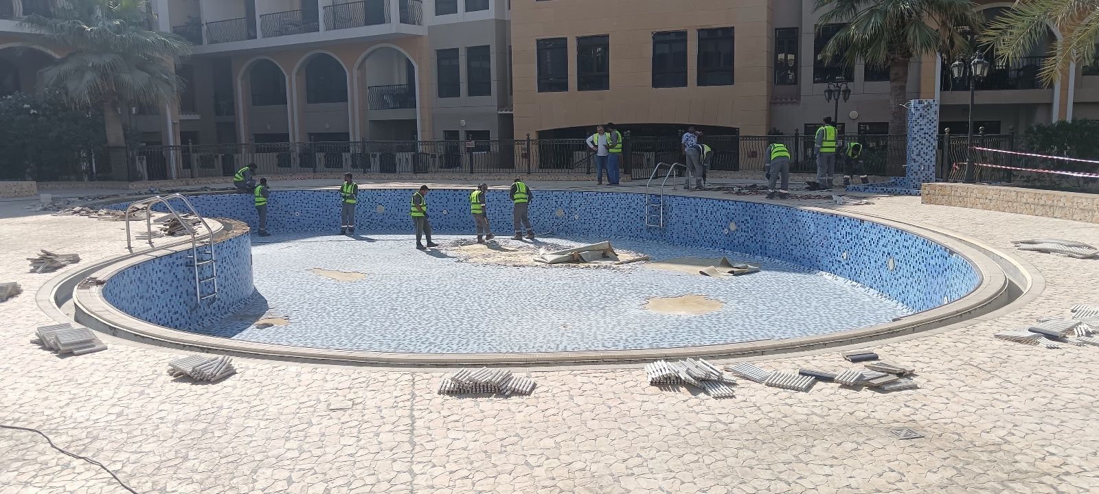 Community pool being re-tiled by the crew — before
