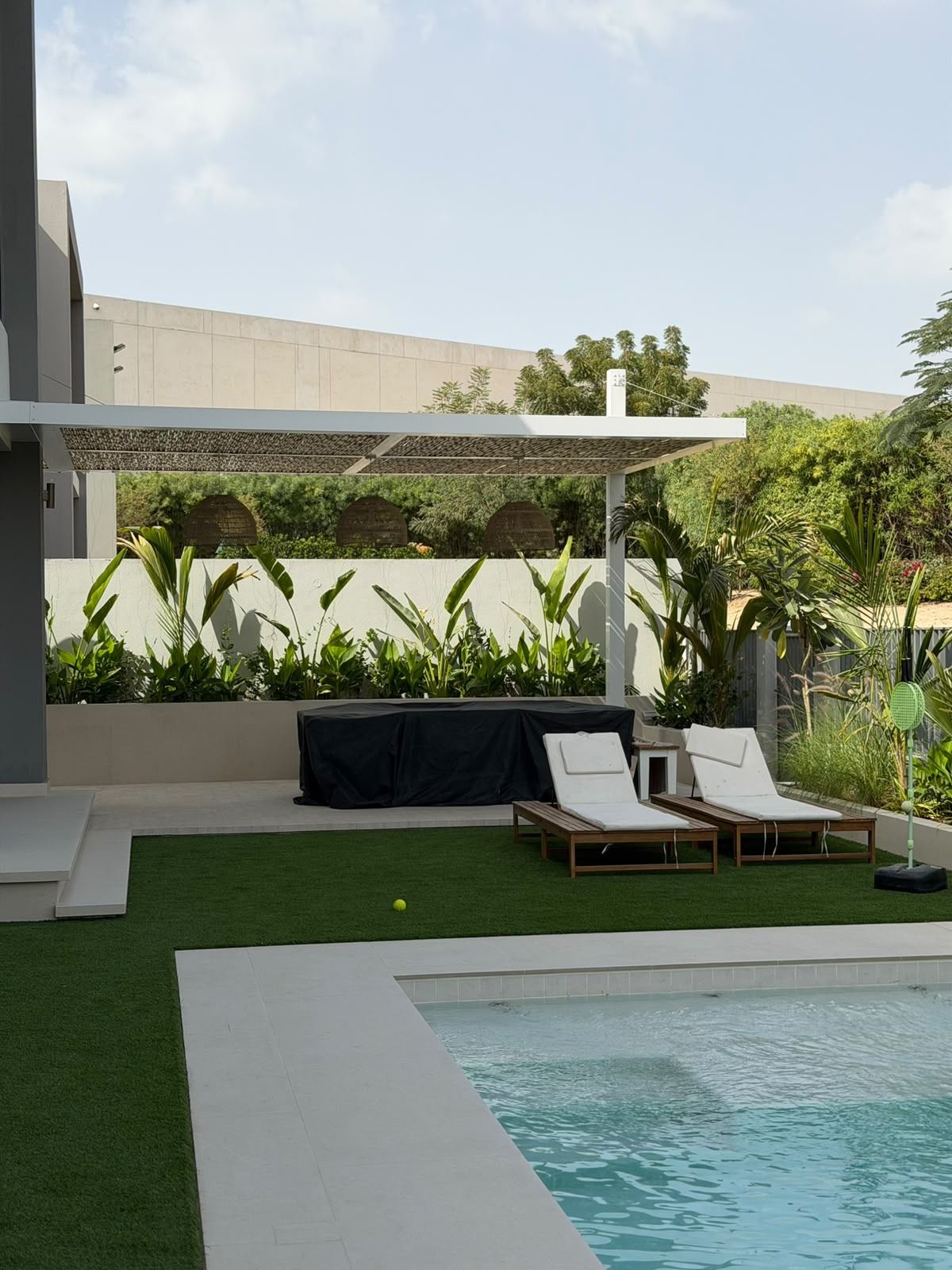 Plunge pool with artificial grass and loungers after makeover