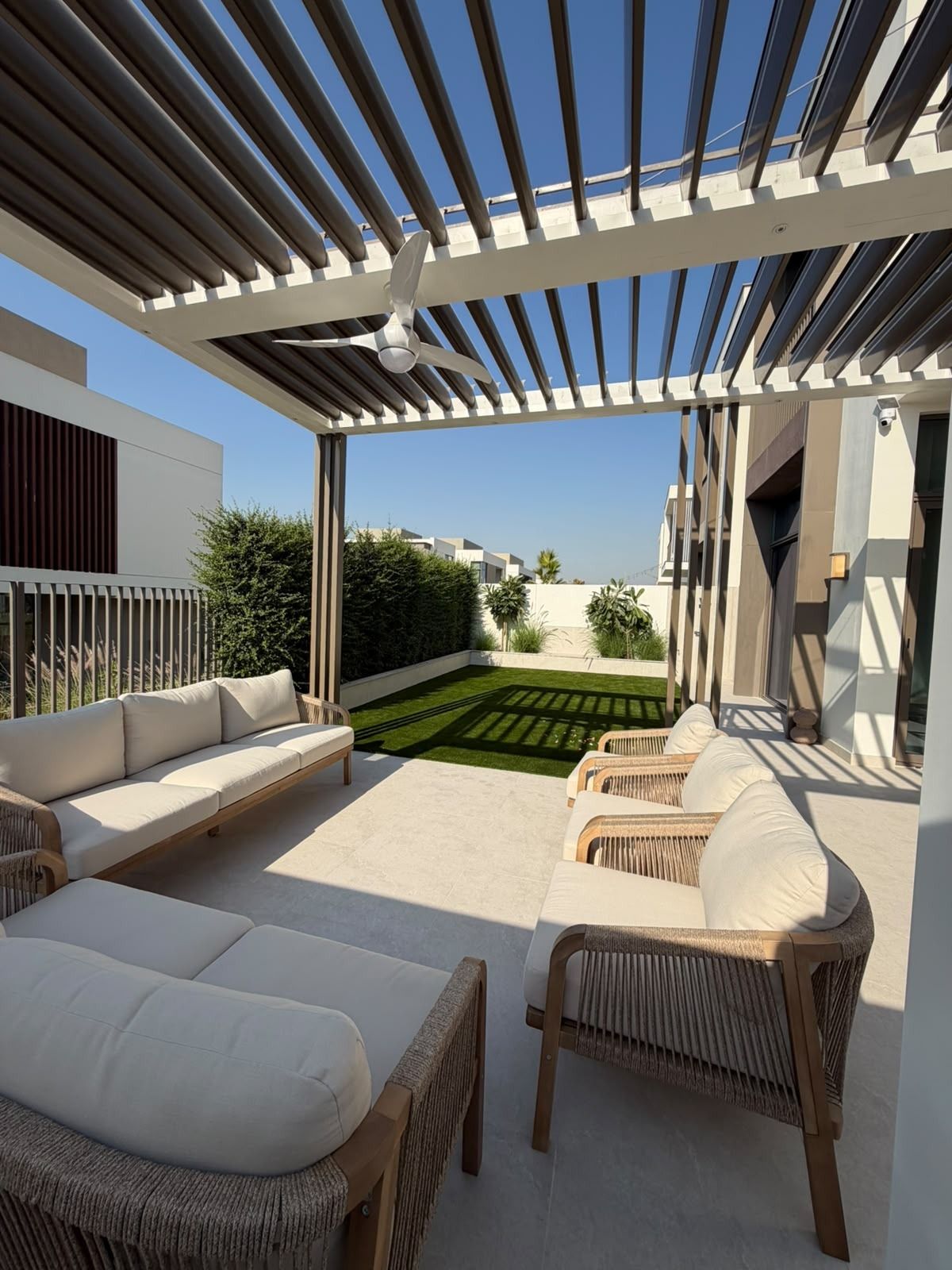 Slatted pergola with fan over an outdoor lounge