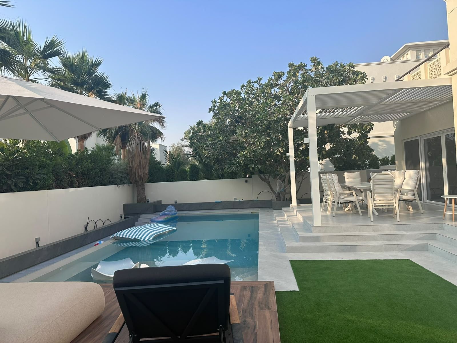 Pool with pergola lounge in a renovated back garden