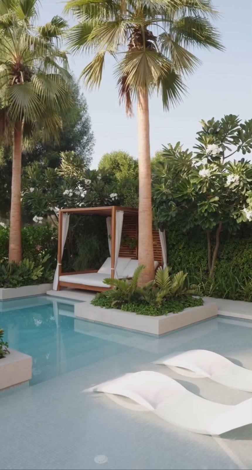 Pool with submerged loungers and tropical planting