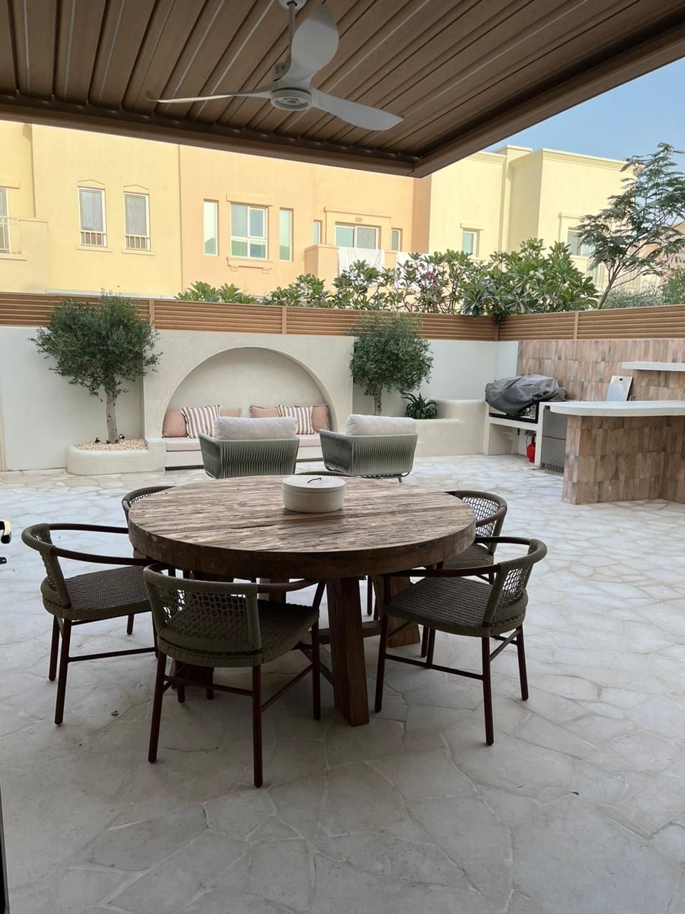 Covered patio with dining table, built-in seating and crazy-paving floor