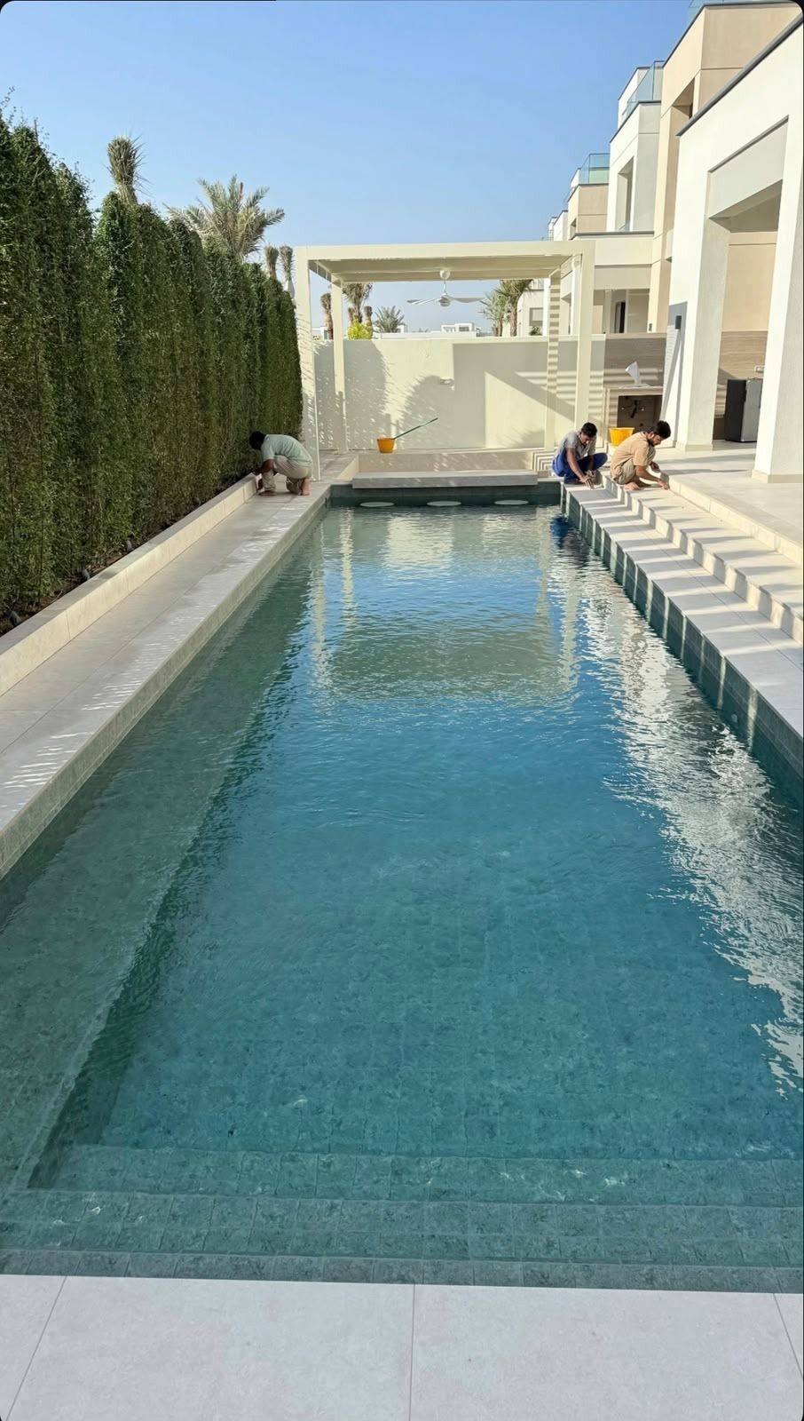 Crew cleaning the new pool and deck before handover