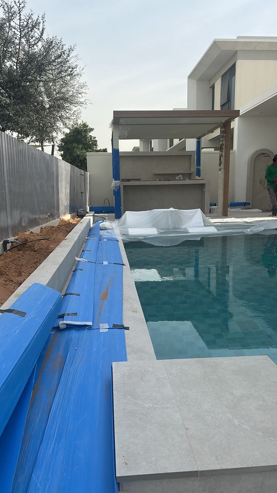 Pool being retiled during a back-garden renovation