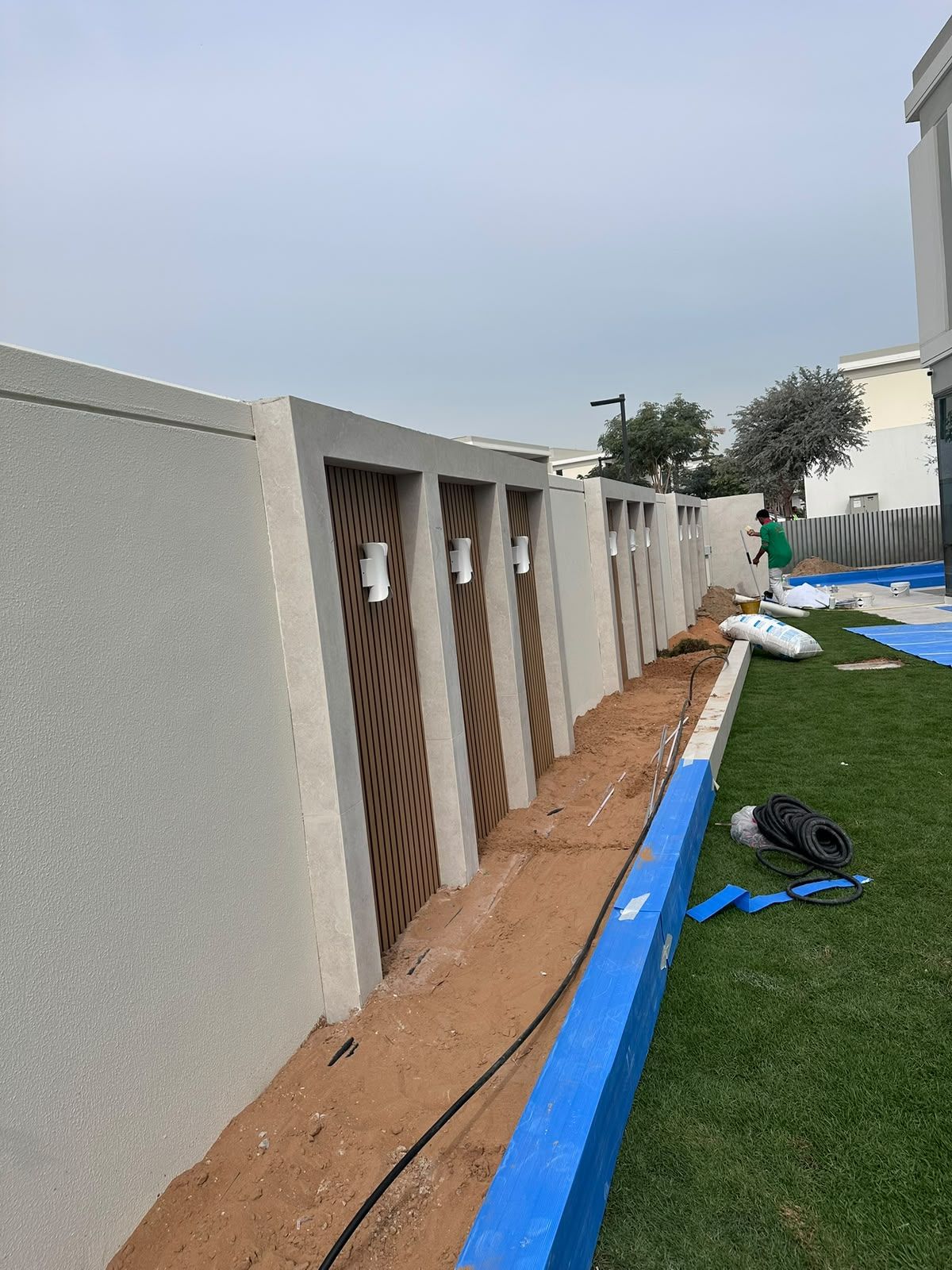 Garden wall rendered and clad with vertical slats during works