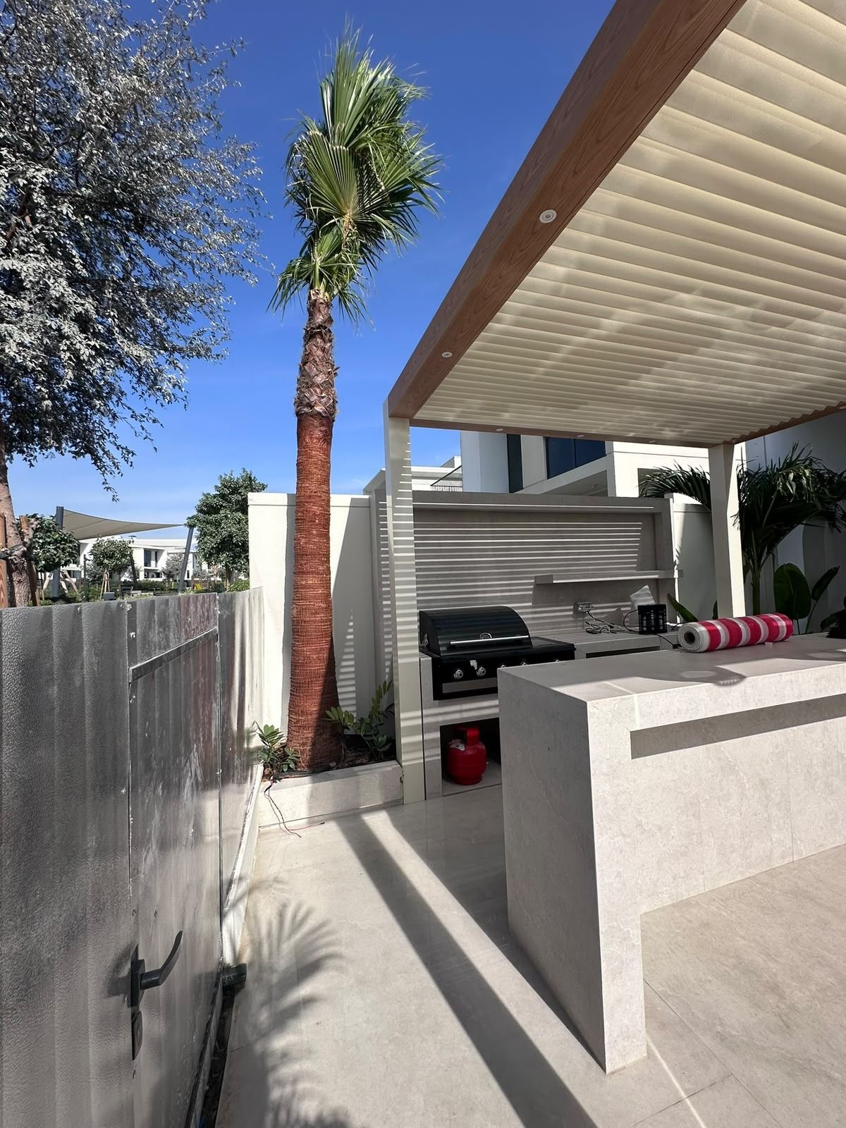 Outdoor BBQ kitchen under a louvred pergola