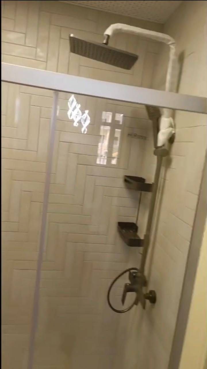 Finished herringbone tiled shower with glass screen — after
