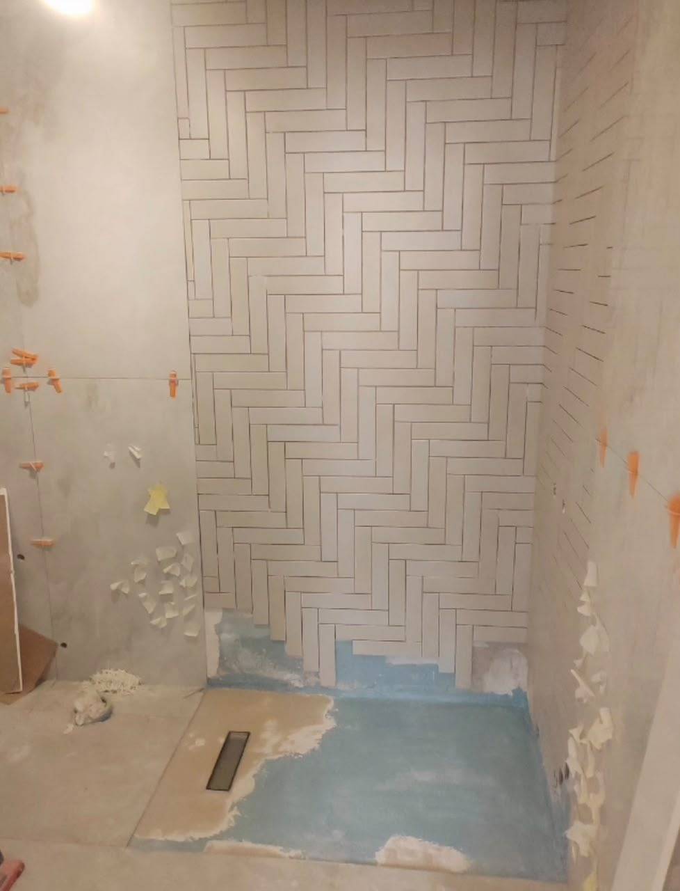 Bathroom mid-renovation with waterproofing membrane on the floor — before